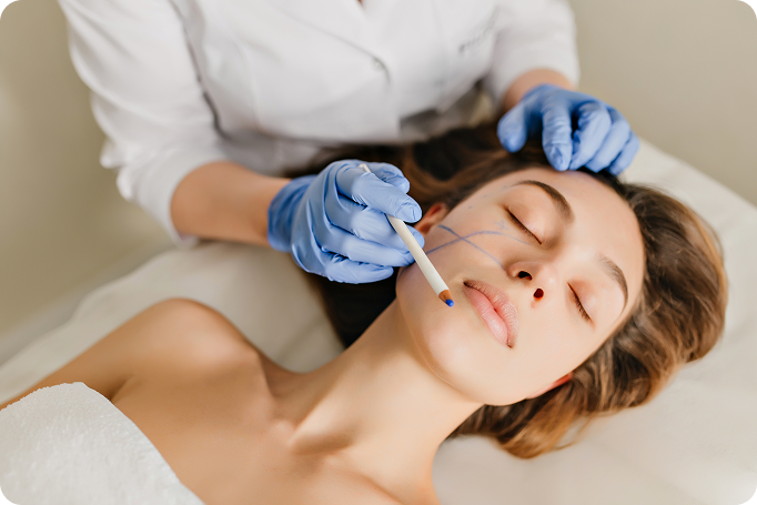 mulher-de-retrato-com-cabelo-castanho-na-preparacao-para-o-rejuvenescimento-operacao-de-cosmetologia-no-salao-de-beleza-maos-em-luvas-azuis-desenhando-no-rosto-botox-beleza-1-1 BIOMEDICINA ESTÉTICA